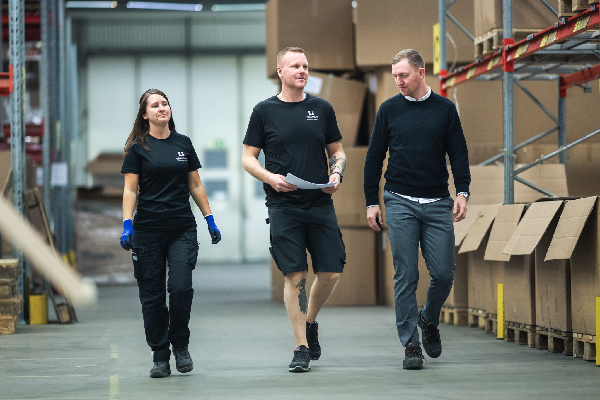 Tre personer i ett industrilager